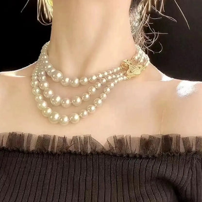 Regal Triple Strand Pearl Necklace with Embellished Orb Accent